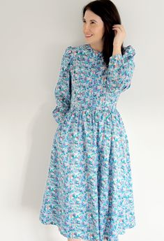 "🤍VINTAGE LIBERTY LONDON BLUE FLORAL MIDI COTTON DRESS🤍 A beautiful classic Spring Summer a line dress which can be dressed up or down. **WELCOME TO SEASONALLY DRESSED** BRAND ~ MARION DONALDSON (famously known for using Liberty fabrics) 👗 Fits like a size: UK  12 TODAY  Label Size: UK 14 Model is a UK 12 | 5ft 6 | Perfect fit  🌎 International Sizing: See converter within Frequency Asked Questions Underarm to underarm (Flat): 19.5\" Waist (Circumference): 30\" Hips (Circumference): free  Shoulder to Hem:49 \" Sleeve length (underarm to cuff):18\" ⭐️ ITEM DESCRIPTION ⭐️ A very rare Marion Donaldson dress using Liberty floral print fabric | The dress is a line shape and has lining | Buttons to the waist | Hidden back zip | Original label and hem | Blue piping details | Ideal for weddings Blue Vintage Dress For Spring Daywear, Blue Vintage Long Sleeve Dress, Blue Knee-length Vintage Dress For Vintage Fashion, Vintage Light Blue Long Sleeve Dress, Vintage Smocked Fitted Dress, Fitted Smock Vintage Dress, Vintage Smock Dress For Daywear, Fitted Vintage Smock Dress, Vintage Long Sleeve Midi Dress For Dress Down