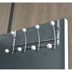 a metal rack with five white balls hanging from it's sides on a wooden wall