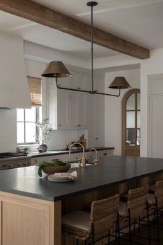 a large kitchen with an island in the middle and chairs at the counter top,