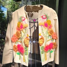 This Is A Beautiful Handmade Tan/Camel Color Jacket With Gorgeous Floral Colorful Embroidery And Felting. This Entire Piece Is Handmade Has Eye Hook Closure And Is Lined On The Front Panels. This Is A Vintage Piece But Looks Brand New. The Material Is Super Soft. Appropriate Measurements: Chest- 15" Length- 16" Sleeves- 16" Please Ask Questions And Make An Offer. I Can't Say Yes If You Don't Ask! Fall Beige Outerwear With Floral Embroidery, Beige Floral Embroidered Outerwear For Fall, Beige Summer Outerwear With Floral Embroidery, Beige Floral Embroidery Summer Outerwear, Embroidered Cream Outerwear For Spring, Fitted Fall Outerwear With Floral Applique, Fitted Floral Applique Outerwear For Fall, Fitted Embroidered Beige Outerwear, Fitted Camel Outerwear For Spring