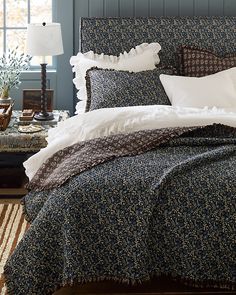 a bed with blue and white comforter in a bedroom