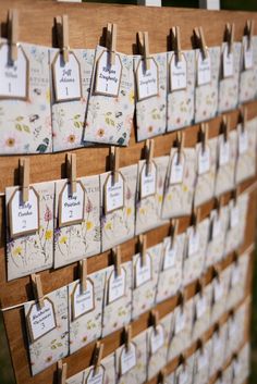 a wooden board with lots of cards attached to the boards and hanging from it's sides