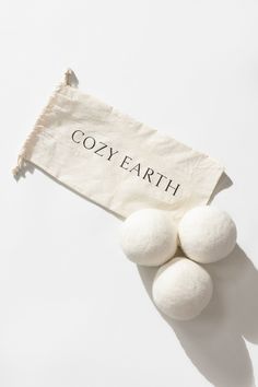 three balls of wool sitting on top of a piece of paper that says cozy earth