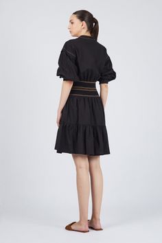 Elevate your style with the Mercy Dress, a perfect blend of elegance and comfort. Crafted from 100% cotton, this mini dress is available in striking blue and classic black, making it a versatile addition to your wardrobe. The pleated ruffled skirt adds a playful touch, while the elasticated belt with contrasting stitching defines your silhouette effortlessly. Featuring a shirt collar V-neckline, buttoned chest, and long sleeves with dropped shoulder details, the Mercy Dress offers both sophistic Daywear Mini Dress With Ruffled Skirt, Mini Dress With Ruffled Skirt For Daywear, Mini Length Ruffled Skirt Dress For Daywear, Chic Mini Dress With Pleated Hem For Daywear, Elegant Pleated Cotton Mini Dress, Cotton Dress With Pleated Waist And Voluminous Skirt, Fitted Mini Dress With Ruffled Skirt For Daywear, Chic Cotton Dresses With Ruffle Hem, Cotton Ruffle Dress With Mini Length