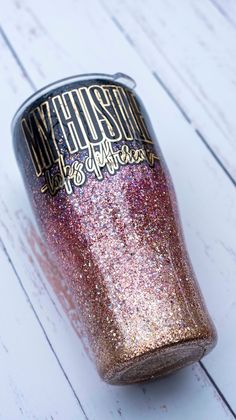 a pink and gold glitter cup sitting on top of a white table next to a wooden floor