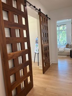 an open door leading to a living room with wood flooring and white walls in the background