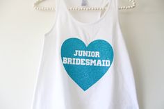 a tank top with the words junior bridesmaid on it hanging from a rack