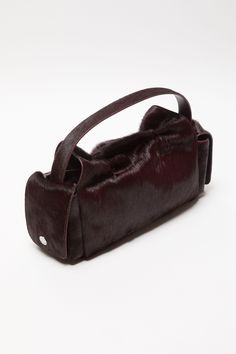 Multipocket bag is crafted from leather with a hairy finish and laced knot details. Complete side flap pocket with a discrete magnetic closure and spacious interior. Includes a top handle and long strap. Complete side flap pocket with a discrete magnetic closure, spacious interior and adjustable shoulder strap. Multipocket Fur Multipocket Bag, Dark Burgundy, Denim T Shirt, Children Shoes, Pocket Top, Leather Pieces, Wardrobe Style, Clothes Collection, Small Leather Goods