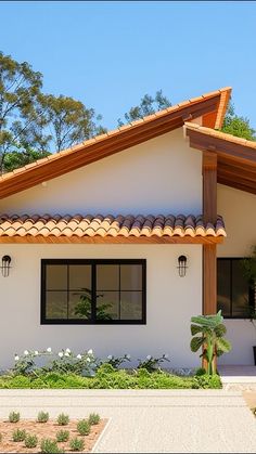 a white house with black windows and brown roof