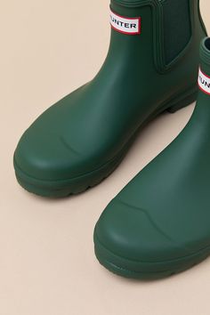 Romanticize rainy days with every step in the Hunter Original Hunter Green Chelsea Rain Boots! These matte rubber rain boots feature a rounded upper that rises to an ankle-high shaft with elastic gussets at the instep and outstep. The slip-on design features a pull tab and a ribbed-textured detail at the back, all atop a sturdy low-block heel. Logo tag at the front. Available in whole sizes only. 0. 75" rubber heel. Lightly cushioned insole. Rubber sole has nonskid markings. Man made materials. Green Boots For Rainy Season, Short Rain Boots, Chelsea Rain Boots, The Hunter, Low Block Heels, Logo Tag, Heel Boots, Rubber Heels, Hunter Green