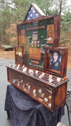 an old wooden machine with pictures on it's sides and medals in the back