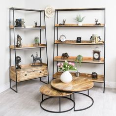 three wooden shelves with vases and other items on them in the corner of a room