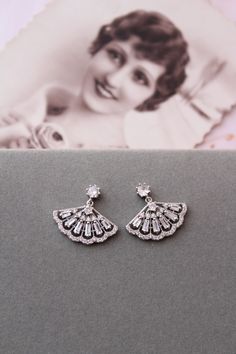 Small  vintage style  earrings   Colour: rhodium(silver tone) /clear. Measurements: approx 21 mmx20mm (small and delicate).  Materials:  rhodium over brass components, micro pave zircon crystals. Stud earrings. Great for wedding or other celebration. MORE SAME STYLE: https://www.etsy.com/uk/shop/BridalArtDeco?ref=listing-shop-header-item-count&section_id=23918122 Please note some images have been enlarged to allow for details to be shown. Read the descriptions for details on actual size of each Classic Silver Diamond Earrings For Wedding, Vintage Pierced Diamond Earrings For Wedding, Art Deco Crystal Drop Earrings For Wedding, Vintage Wedding Diamond Earrings, Pierced, Vintage Wedding Diamond Earrings, Art Deco White Gold Wedding Earrings, White Gold Art Deco Wedding Earrings, Silver Pierced Cluster Earrings For Wedding, Vintage White Gold Earrings For Wedding