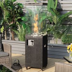 an outdoor fire pit sitting on top of a patio next to some chairs and potted plants