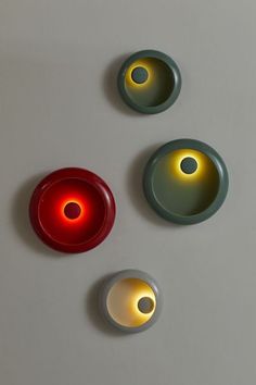 three circular lights are on the wall next to each other, one red and one green