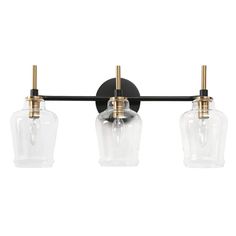 three light bathroom fixture with clear glass shades and brass fittings on the back wall