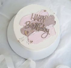 a birthday cake with the words happy birthday written on it in gold and pink frosting