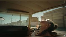 a woman sitting in the back seat of a car with her eyes closed and mouth open