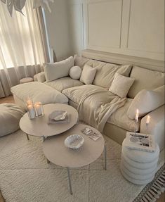 a living room filled with lots of furniture and candles on top of the coffee table