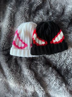 two knit hats laying on top of a fur blanket