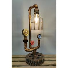 a steampunk table lamp with pipes and a light bulb on it's side