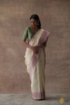 "Delicate, timeless, silken splendour! With the\u00a0beautiful\u00a0zari\u00a0bootis on katan silk, exquisite Paithani inspired\u00a0borders and an intricately artistic pallu on a bed of gossamer silk tissue, this is a\u00a0beautiful handwoven reminder of our rich heritage.\n\u00a0\n\n\nColor\u00a0- A beautiful\u00a0shade of Cream with a Pink tissue border\n\n\nTechnique\u00a0- Classic handwoven Banarasi art passed down through generations\u00a0with a unique Paithani style border in which\u00a0a\u00a0zari\u00a0weft is used to form\u00a0a rich golden ground.\u00a0\n\n\nFabric\u00a0-\u00a0Soft as butter, pure Katan Silk with a pure Silk tissue pallu\n\nSpeciality\u00a0-  A delicate pattern, zari, and a traditional floral meenakari paithani border and aanchal make this saree\u00a0a\u00a0quint Katan Silk, Kanjivaram Sarees, Pastel Green, Handloom Saree, Blouse Piece, Pure Silk, Silk Sarees, Soft Fabrics, Light Pink