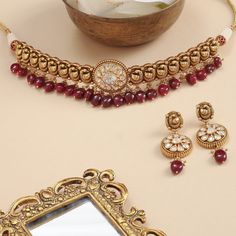 Description An opulent choker fit for a bride, this intricate gold plated silver neckpiece is the definition of regalia. A sequence of Mayurs have been expertly crafted out of the traditional Nakshi technique. This head-turner also features a moissanite studded center motif sparkling like the sun. Semi-precious rubies and pearl clusters add a royal charm to this choker set that come with an equally stunning set of drop earrings. Product Information Materials used: 925 Silver with Antique Gold Pl Elegant Hand Set Kundan Necklace For Rituals, Hand Set Bollywood Jewelry For Rituals, Tilla Choker For Reception, Tilla Choker For Reception Occasion, Tilla Choker Jewelry For Reception, Festive Bollywood Style Choker Necklace, Hand Set Choker Necklace For Receptions, Elegant Gold Bridal Necklace For Rituals, Traditional Hand Set Kundan Necklace For Rituals