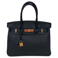 Hermes Black Birkin 30 Bag. Excellent condition. Looks like new. Plastic is still on the hardware. Gold hardware. Togo leather. The most wanted and desired black with gold hardware. Iconic combination and size 30. Interior clean. Includes clochette, lock, keys, and dust bag. Guaranteed authentic. Don't miss out on this one. Black Business Bag With Turn-lock Closure, Classic Gold Bag With Turn-lock Closure, Gold Office Bag With Turn-lock Closure, Gold Business Bags With Brass Hardware, Black Rectangular Satchel With Lock, Gold Travel Bag With Turn-lock Closure, Luxury Black Satchel With Gold-tone Hardware, Gold Satchel With Branded Hardware For Business, Black Bags With Lock For Daily Use