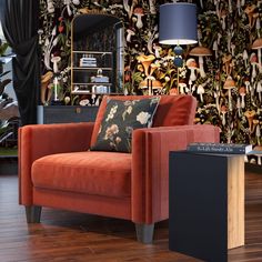 an orange couch sitting in front of a wall with mushrooms on it and a lamp next to it