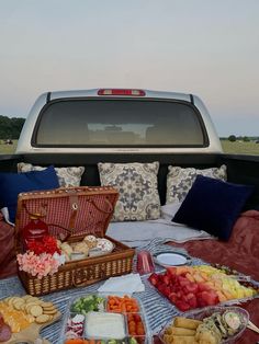 the back of a pickup truck filled with lots of food on top of a blanket