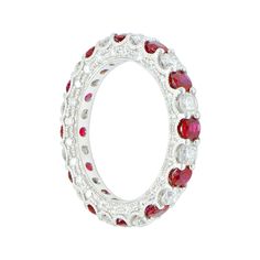 a white gold ring with red and white stones on the inside, surrounded by diamonds