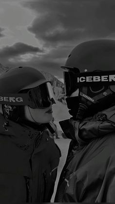 two people wearing helmets standing next to each other