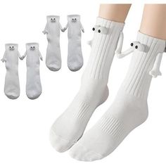 four pairs of white socks with black eyes and noses on the bottom, one pair is for