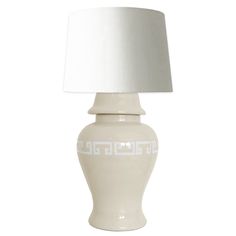 a white table lamp with a white shade on it's base and greek motif