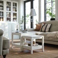 a living room filled with furniture and a white coffee table on top of a rug