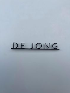 the word delong is written in black on a white wall