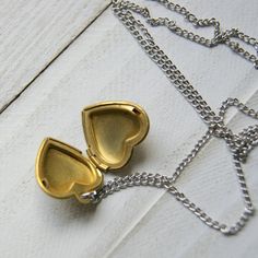 "A vintage brass heart locket hangs from a vintage stainless steel chain to make this simple and easy to wear necklace. The locket measures 7/8\" long and is NOS (new old stock) vintage with varying amounts of patina and scratches on the surface. Choose length at checkout: 16\". 18\". 20\". 22\". 24\". More heart jewelry can be found here: http://etsy.me/1Stzj2o To see more of my handmade jewelry in my Etsy shop, click this link: WearYourWild.etsy.com All jewelry comes nestled in recycled, rusti Vintage Brass Heart Charm Necklace, Vintage Charm Heart-shaped Brass Necklace, Brass Heart Necklace With Vintage Charm, Brass Heart Charm Necklace For Gift, Brass Heart Charm Necklace Perfect For Gifts, Brass Charm Necklace With Heart Charm For Gifting, Brass Charm Necklace With Heart Charm For Gift, Brass Charm Necklace With Heart Charm As Gift, Gold Brass Heart Pendant Locket Necklace