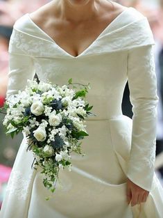 a woman in a white wedding dress holding a bouquet