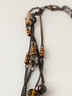 Beautiful vintage boho style necklace. Teardrop shaped tigers eye stone pendant with a filigree cutout copper-tone accent on top. The tigers eye has two small chips along the bottom but they're almost impossible to see. Strung on four antiqued bronze tone chains with pearl shell chips, crystal beads and copper colored faux pearls accents. Pendant measures 1.75 inches long. Necklace is 16 inches long with a lobster claw clasp and 3 inch adjustable chain. Shop Policies: Shipping: All items will be Bohemian Brown Metal Necklace, Brown Brass Bohemian Necklaces, Bohemian Metal Teardrop Necklace, Bohemian Teardrop Metal Necklace, Bohemian Brown Brass Necklaces, Brown Bohemian Brass Necklace, Bohemian Brown Brass Necklace, Brown Metal Dangle Necklaces, Bronze Metal Necklaces With Natural Stones