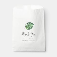 a white paper bag with a green leaf on it and the words thank you written in black