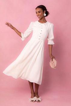 The Ruth Dress showcases a sheer material with a delicate lace peter collar detail. Her fit and subtle flare silhouette adds a touch of elegance, while the tea length provides a timeless look. The non-functional buttons on the bodice are charming and feminine, and the sophisticated cream color complete the design. Ivy City Women's Ruth Dress | Size: 14 Ivy City Co, Pom Pom Dress, Lover Dress, Shower Outfits, Modesty Outfits, Bridal Shower Outfit, City Woman, Bridal Jumpsuit, Bridal Shower Dress