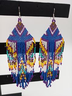 "Beautifully handmade Native American Style Seed Bead Earrings with woven in a combination of desert and mountain colors. Traditional native style design at nearly 6\" off the ear. Colors and styling great for matching your favorite dancing regalia or to wear on its own. Made with stainless steel ear wires and genuine high quality beads. All handmade and Shipped Free from Hawaii with Aloha!" Powwow Regalia, Beaded Earrings Native, Desert Colors, Native American Style, Native Design, Handmade Earrings Beaded, Native Style, Design Seeds, Native American Fashion