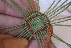 someone is stitching something with green and red thread