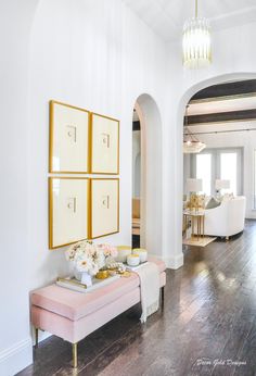 a living room filled with furniture and a chandelier hanging from the ceiling over a wooden floor