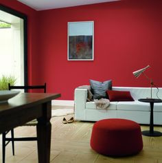 a living room with red walls and white furniture