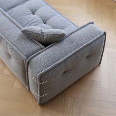 a grey couch sitting on top of a hard wood floor