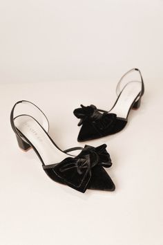 Elevate your style with the Eloise Black Bow Heel. Crafted from smooth black velvet and featuring a closed-toe design, these shoes provide timeless luxury with an elastic stretch strap against the back of the heel for stability and comfort. Step out in confidence with our first ever Ivy SHOES. Available in sizes 5.5, 6, 6.5, 7, 7.5, 8, 8.5, 9, 9.5, 10, + 10.5 & matching minis!! bow heel, womens shoe, wedding shoes, black heels, black bow, bow, elegant shoe, bridesmaid shoes, slingback heel Black Bow Sandals, Black Pointed Toe Slingback Pumps For Gala, Black Slingback Pumps With Ankle Strap For Gala, Black Ankle Strap Slingback Pumps For Gala, Gala Slingback Pumps With Heel Strap And Round Toe, Black Almond Toe Slingback Pumps With Leather Sole, Velvet Heels For Evening, Velvet Evening Heels, Black Slingback Pumps With Wrapped Block Heel