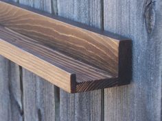 a close up of a wooden door handle on a wood paneled wall with planks