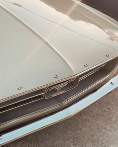 the front end of an old muscle car with chrome paint and metal grills on it