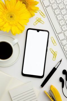 an office desk with yellow flowers, notepad and keyboard